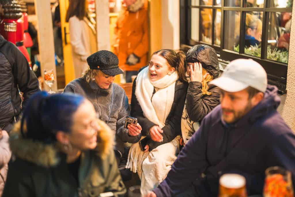Group of people gathered in White Horse Bar, socialising and enjoying drinks in warm lighting.